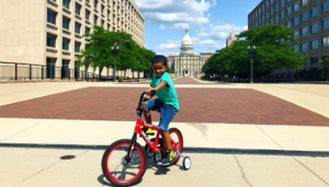 A day in Downtown Lansing Kid riding bike on path Lansing Capitol Building