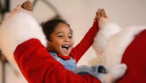 Santa Claus playing with cute Child Lansing Santa Tracker Header