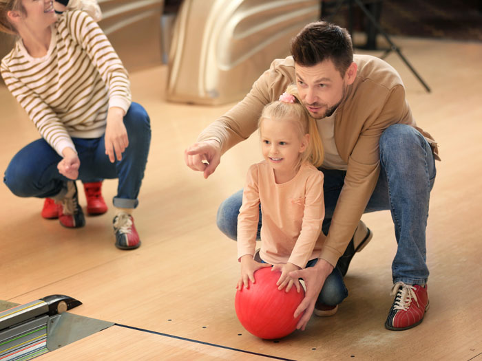 Kids-Bowl-Free-Dad-helping-daughter-girl-bowling-alley-Lansing Kids-Bowl-Free-Dad-helping-daughter-girl-bowling-alley-Lansing