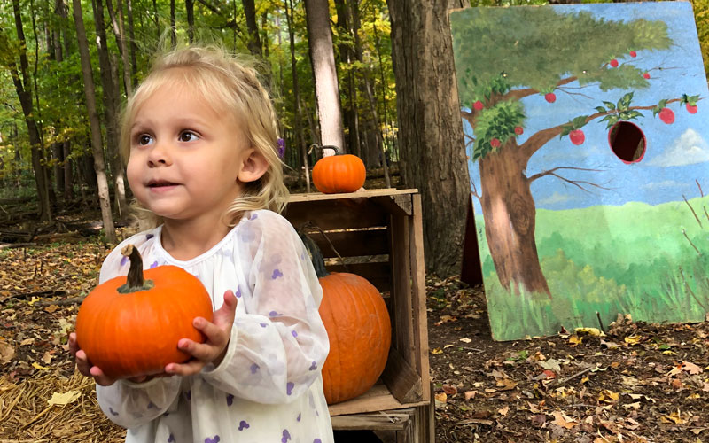 Fall-Things-to-do-Feature-girl-holding-pumpkin-at-Fenner-Nature-Center-Apple-Butter-Festival