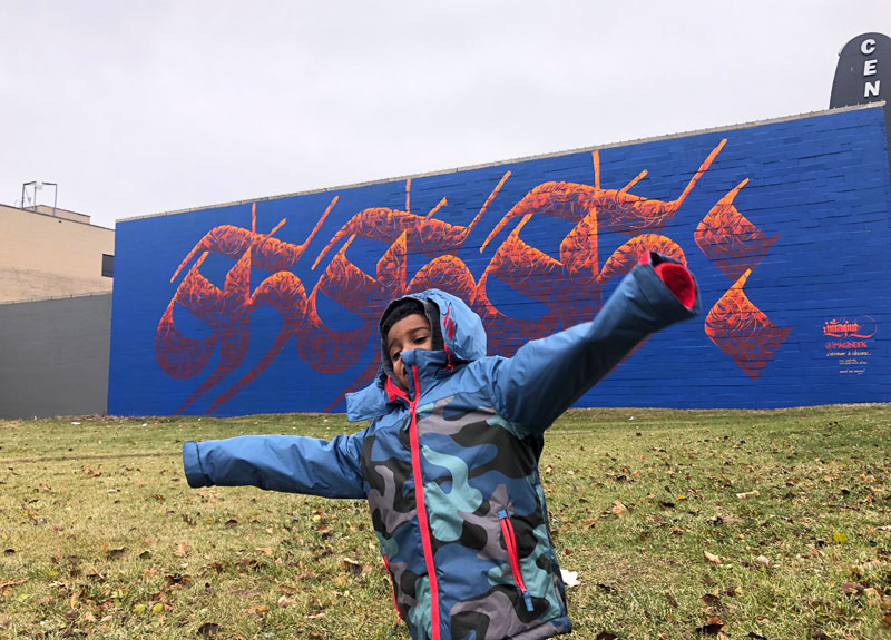 Imagine's-street-art-mural-piece-for-Lansing-kid-spinning-free-in-the-field