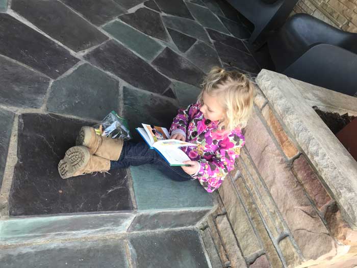 Reading_at_home-girl-reading-on-the-steps-outside