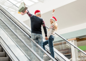 parents-going-up-escalator-with-gifts-and-santa-hats