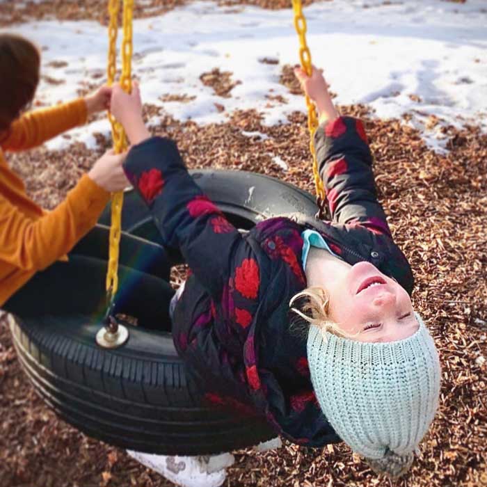 Winter-blues-and-SAD-hacks-girl-playing-on-tire-swing