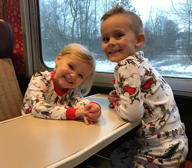 Polar Epress North Pole Express Owosso Kids smiling in Train in Santa Jammies