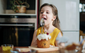 Kid-girl eating-a-cupcake-at-home-kid-friendly-curbside-food-list-Lansing-feature