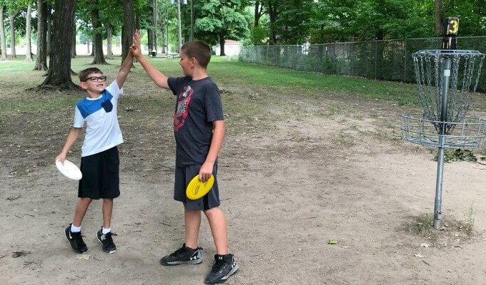 disc-golf-boys-high-fiving-feature-image-1-680x400
