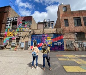 muralmatics feature women looking at mural downtown lansing